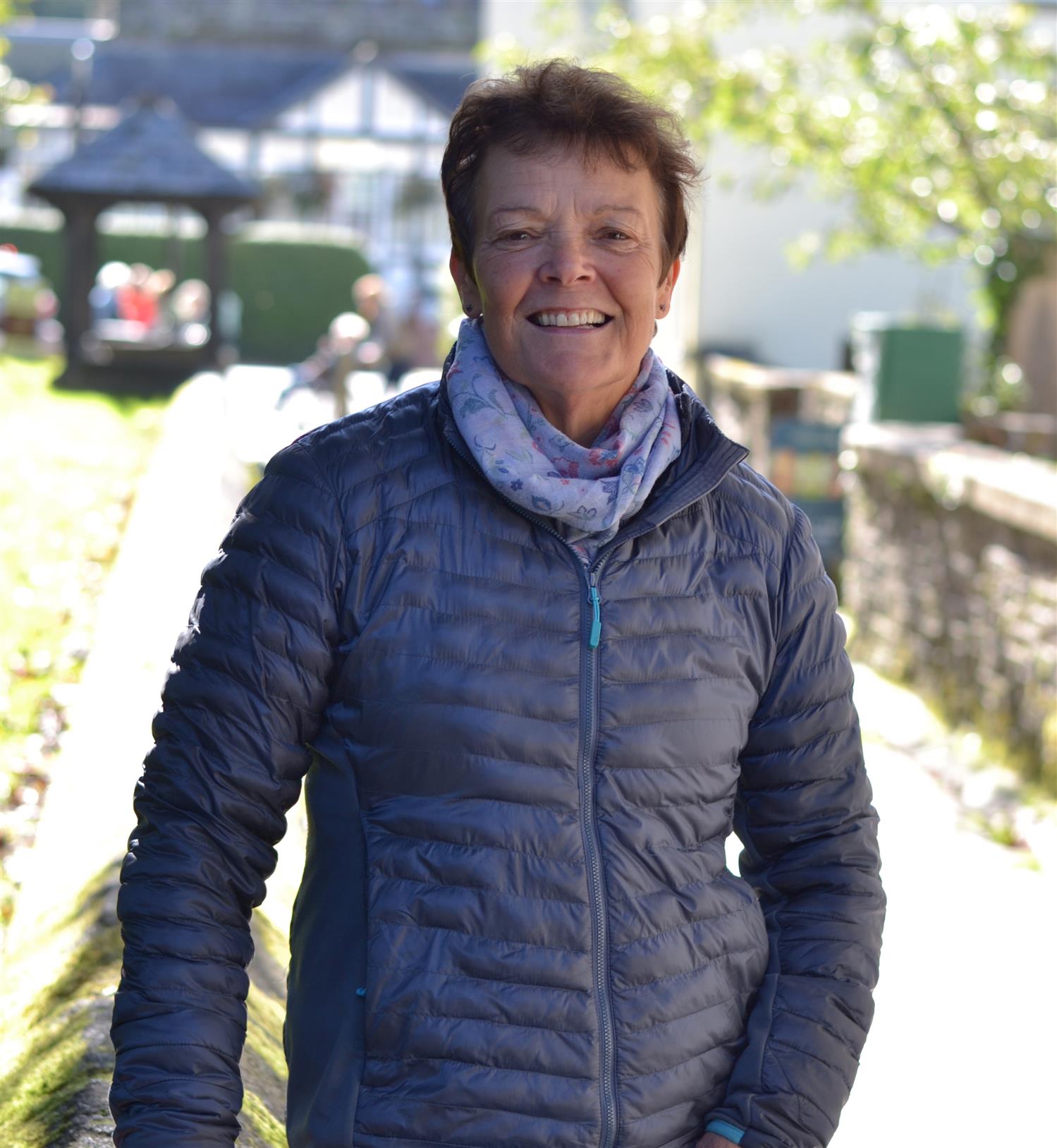 A smiling woman walking near a church